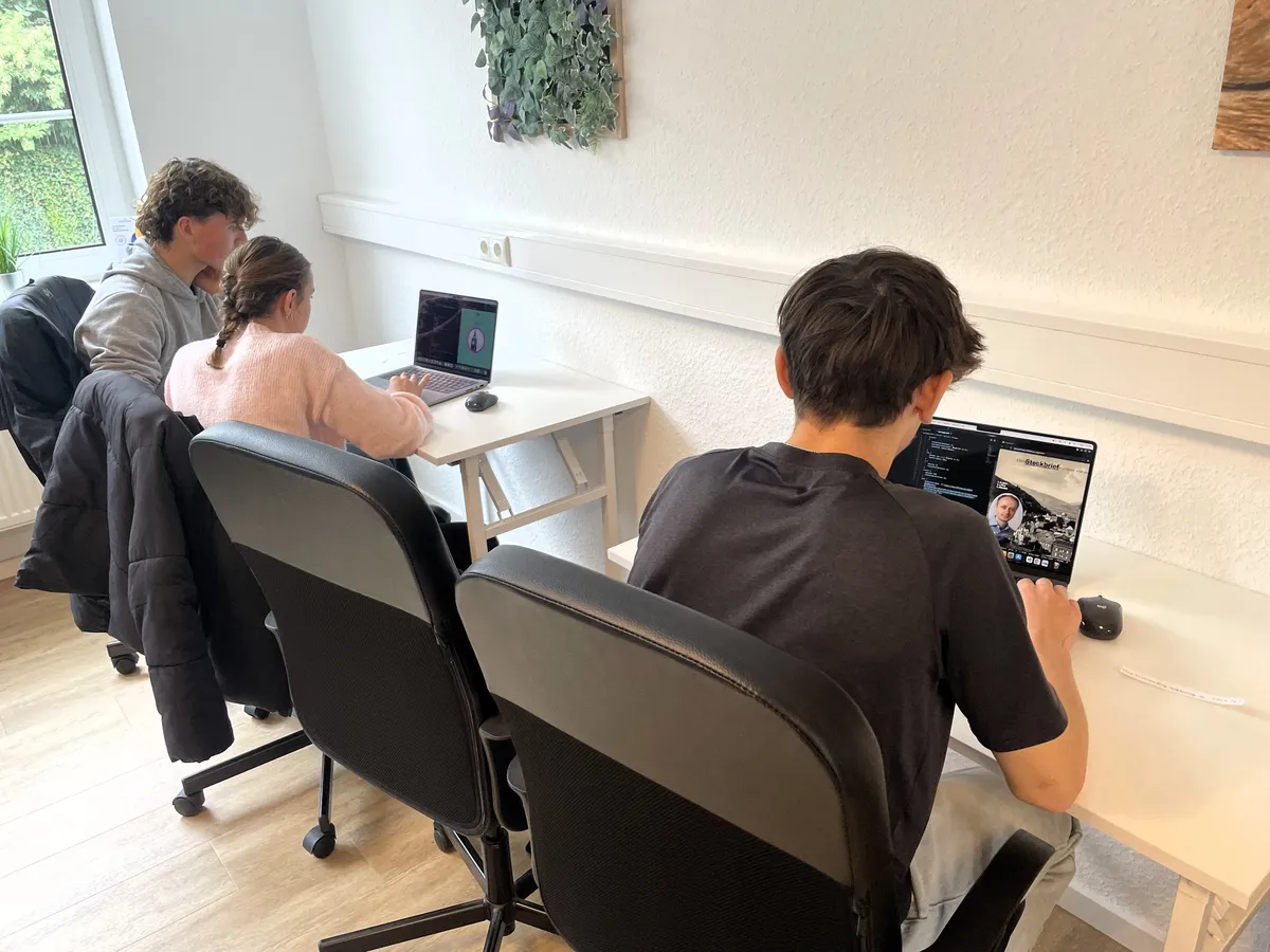 Schülerinnen und Schüler programmieren nebeneinander an ihren Laptops